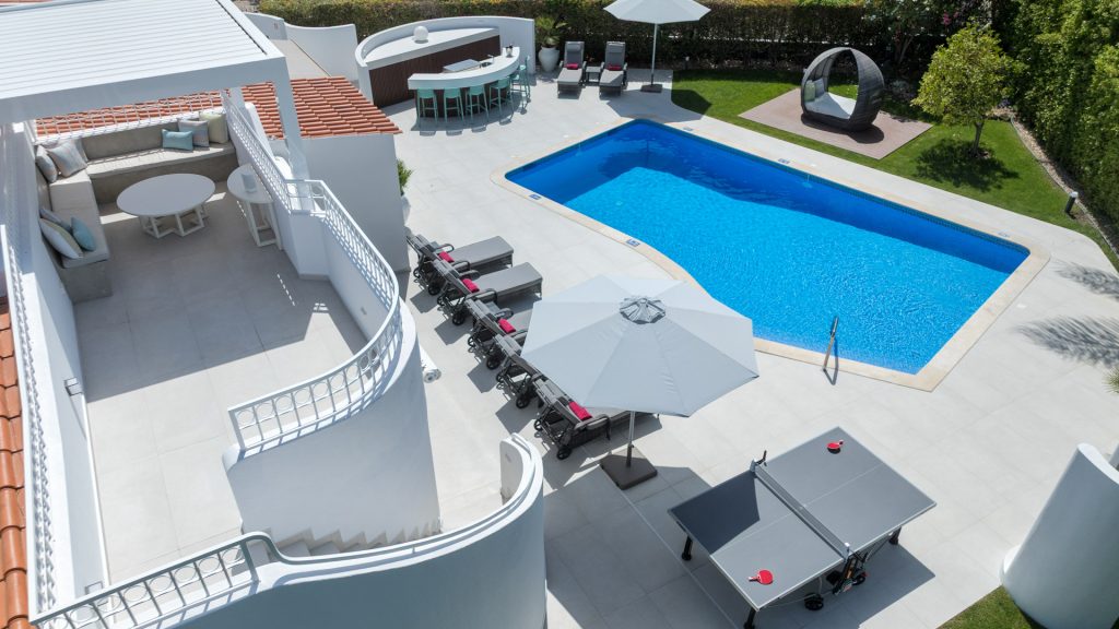 Comfortable outdoor lounge area with cushioned sofas by the private pool